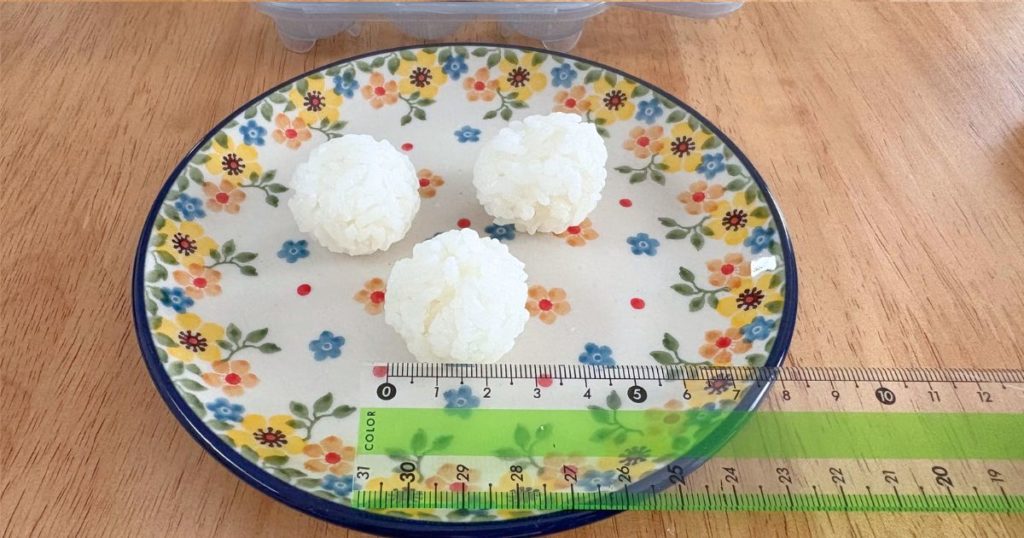ダイソーの「ひとくちおにぎりメーカー」で作ったおにぎりの大きさを測っている写真