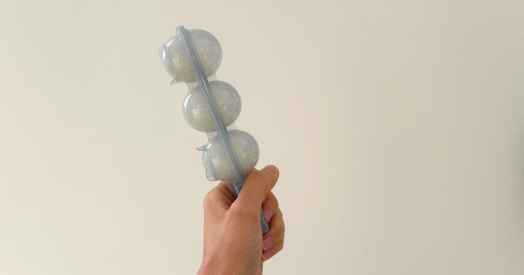 ダイソーの「まんまるおにぎりメーカー」を振っておにぎりを作っている写真