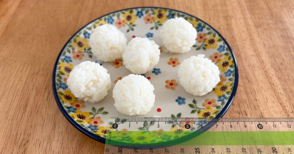 セリアの「ふるだけごはんメーカー」で作ったおにぎりの大きさを測っている写真