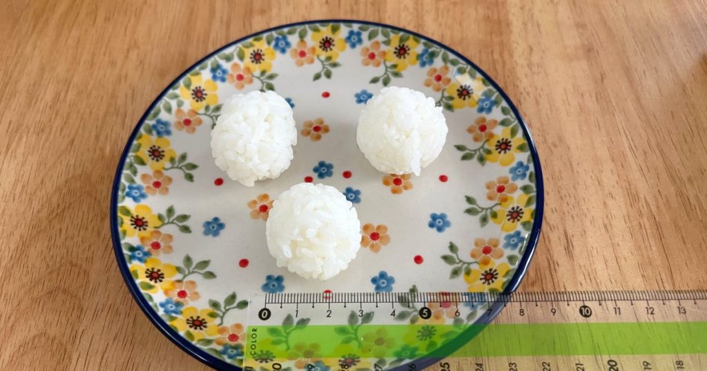 セリアの「ふりふりごはんボール」で作ったおにぎりの大きさを測っている写真
