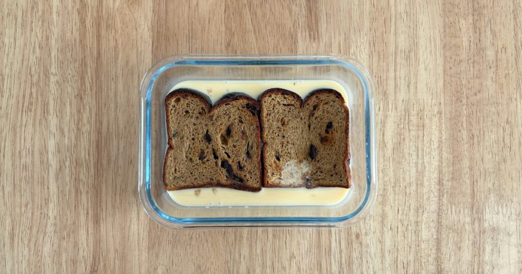 「ベースブレッド・ミニ食パンレーズン」を使ったフレンチトーストを作る途中の、卵液にベースブレッドを浸している写真