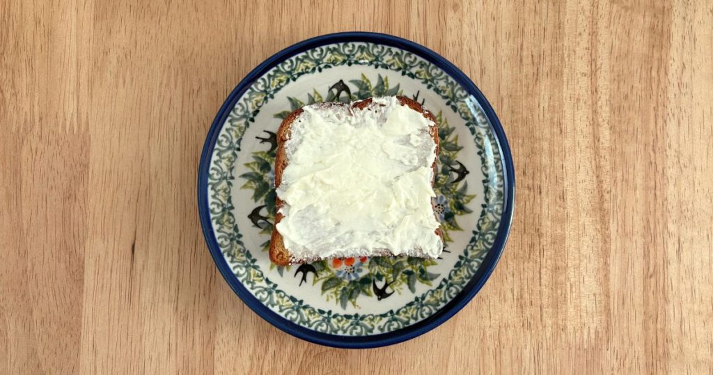 ベースブレッド　ミニ食パン・オレンジでチーズケーキ風トーストを作る工程（クリームチーズを塗る）の写真