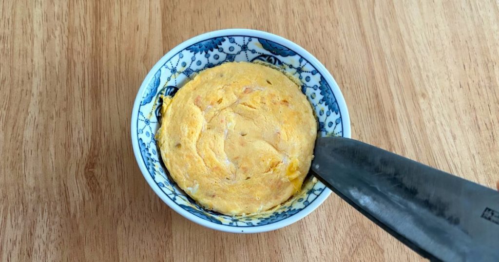 せいろで作った離乳食完了期用の蒸し玉子を、包丁を使って切り分ける様子。