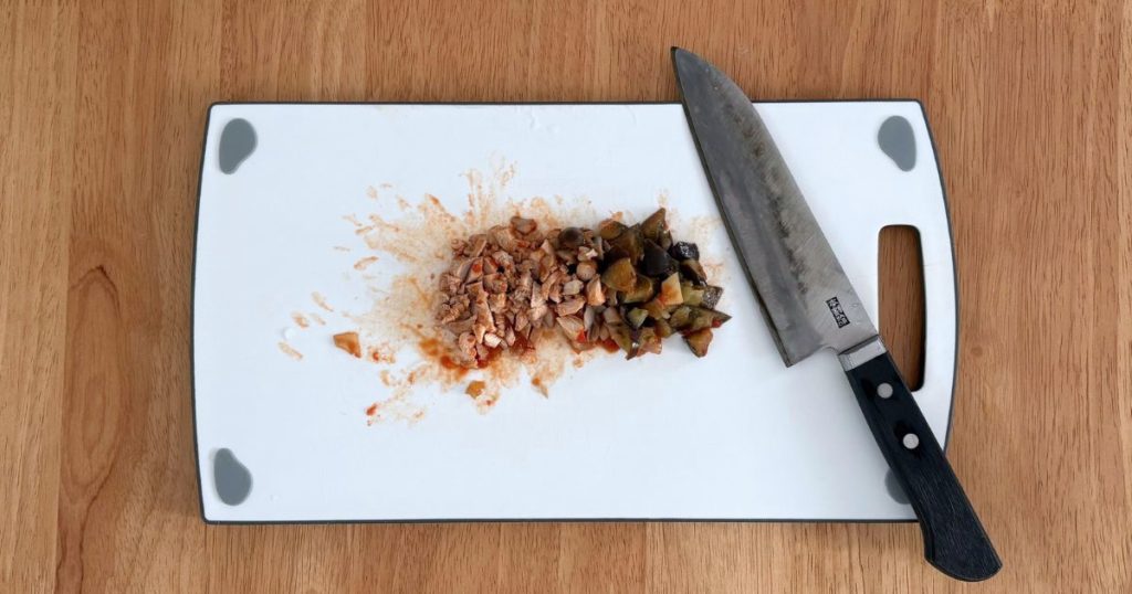 離乳食完了期の取り分けレシピ「鶏もも肉となすのトマト煮込み」の、大きい具材を子ども用にカットする行程