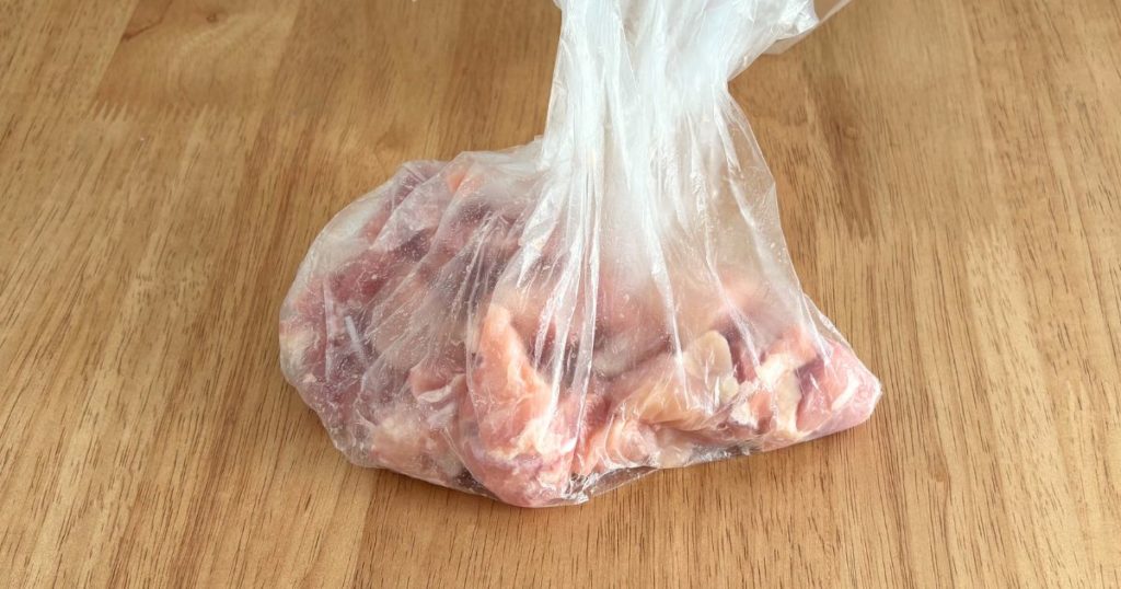 離乳食完了期の取り分けレシピ「鶏もも肉となすのトマト煮込み」の、鶏もも肉に酒を揉みこむ行程